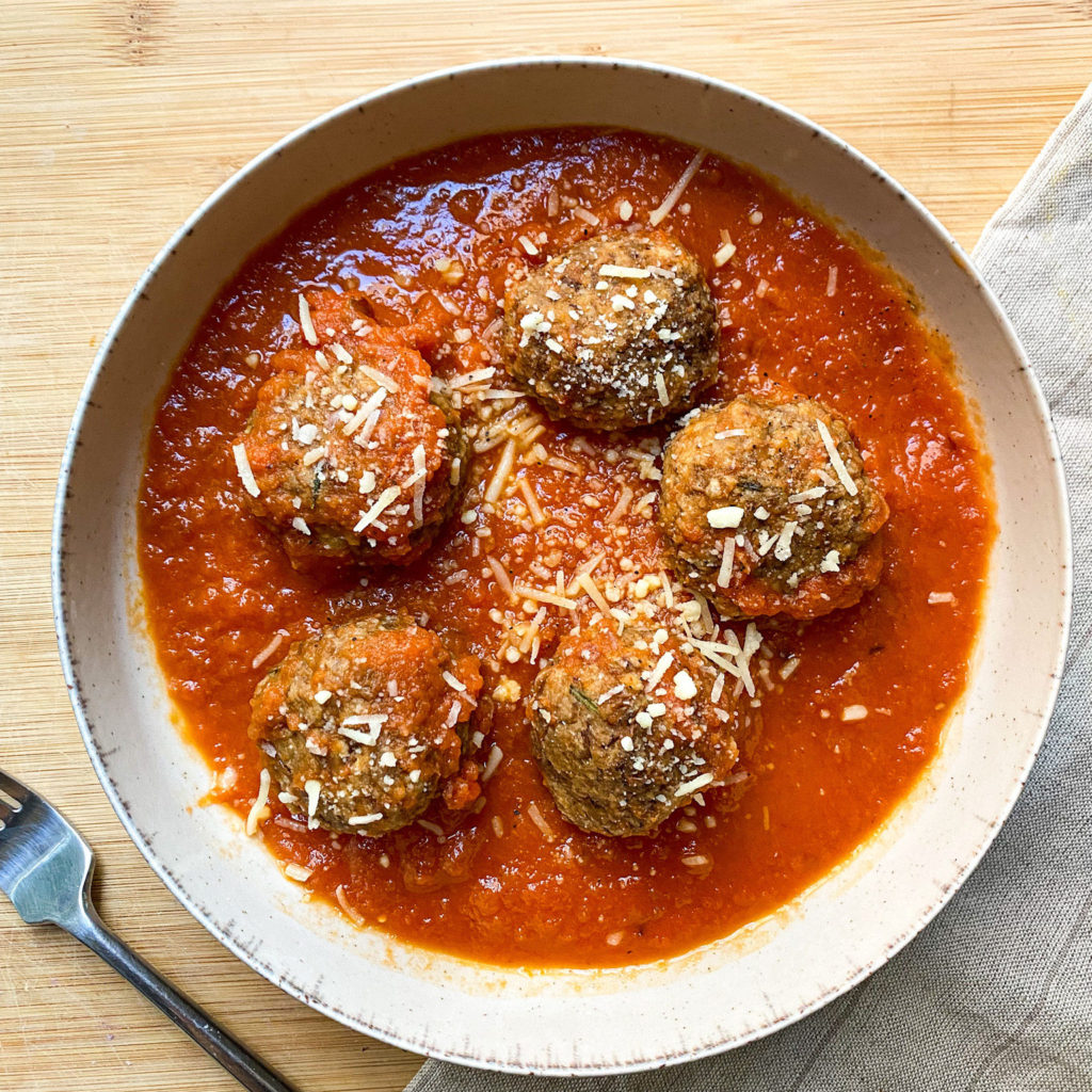 Plate with Vegan Lentil Meatballs in tomato sauce with vegan parmesan