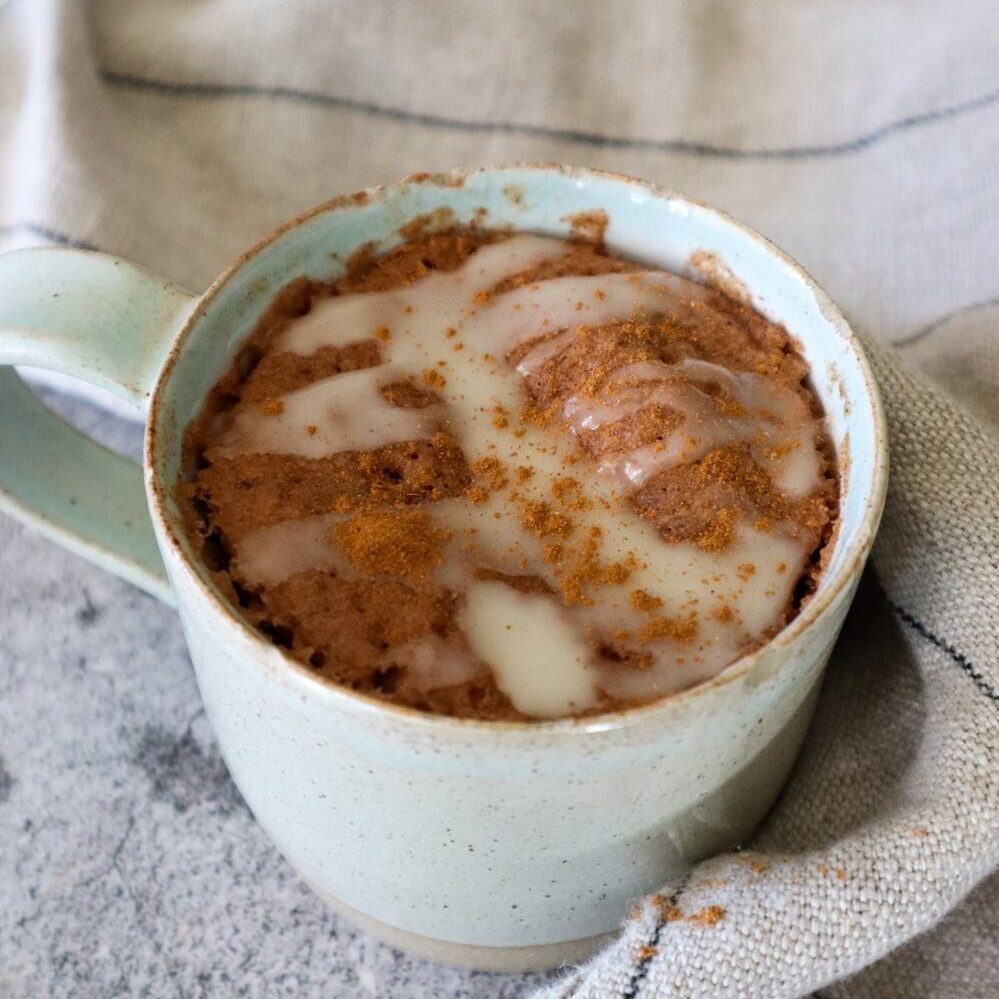 Gingerbread mug cake garnished with icing and cinnamon