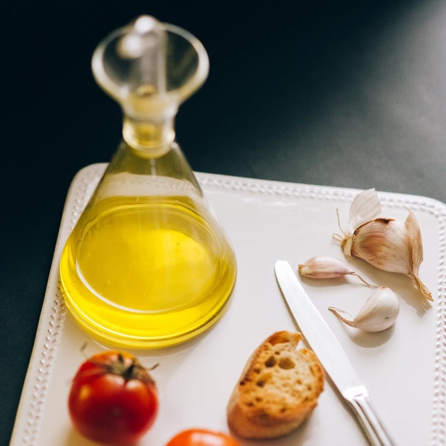 red cherry fruit beside clear glass bottle on white ceramic tray