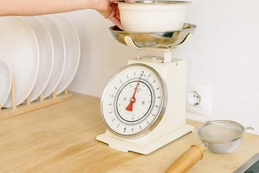a hand weighing the bowl on a scale