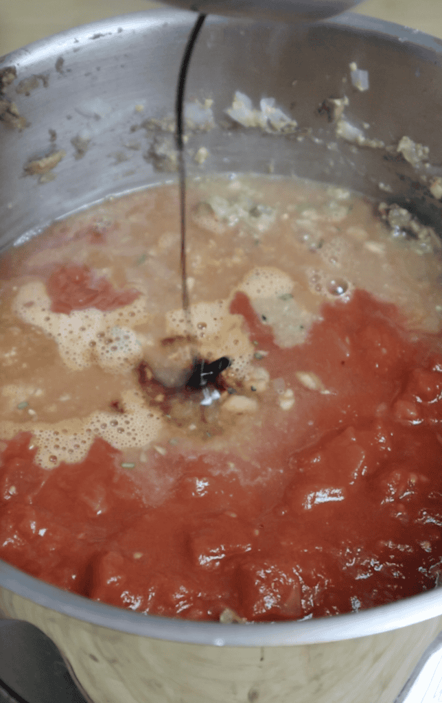 tomato sauce and soy sauce added to a pot