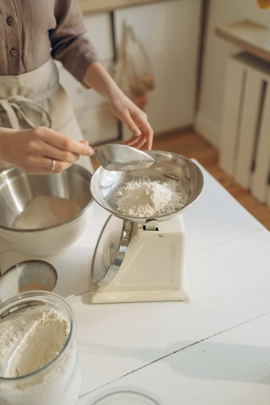 a person putting the flour on a weighing scale