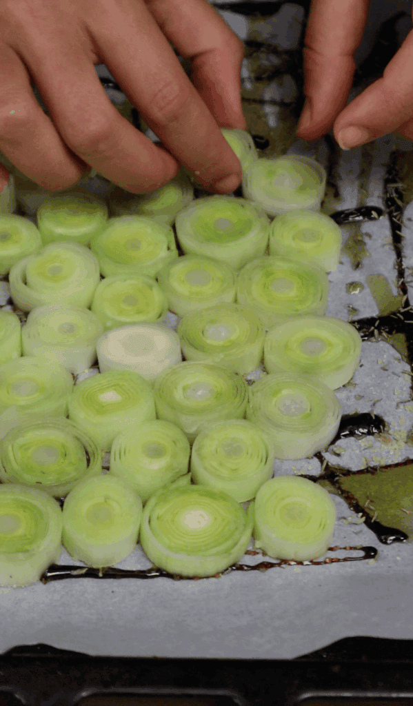 leeks being arranged on baking paper