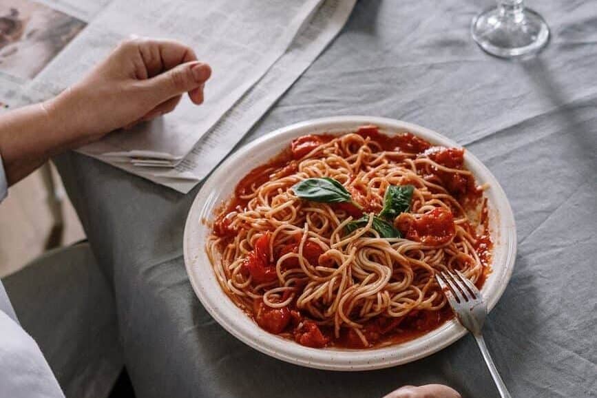 person having a plate of spaghetti for meal