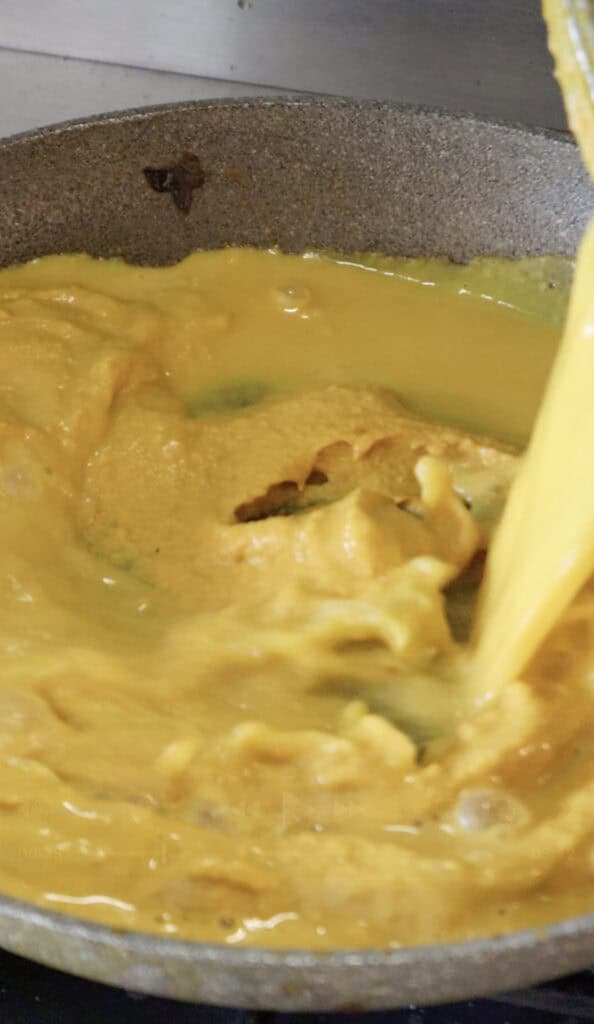 sauce being mixed with pasta water