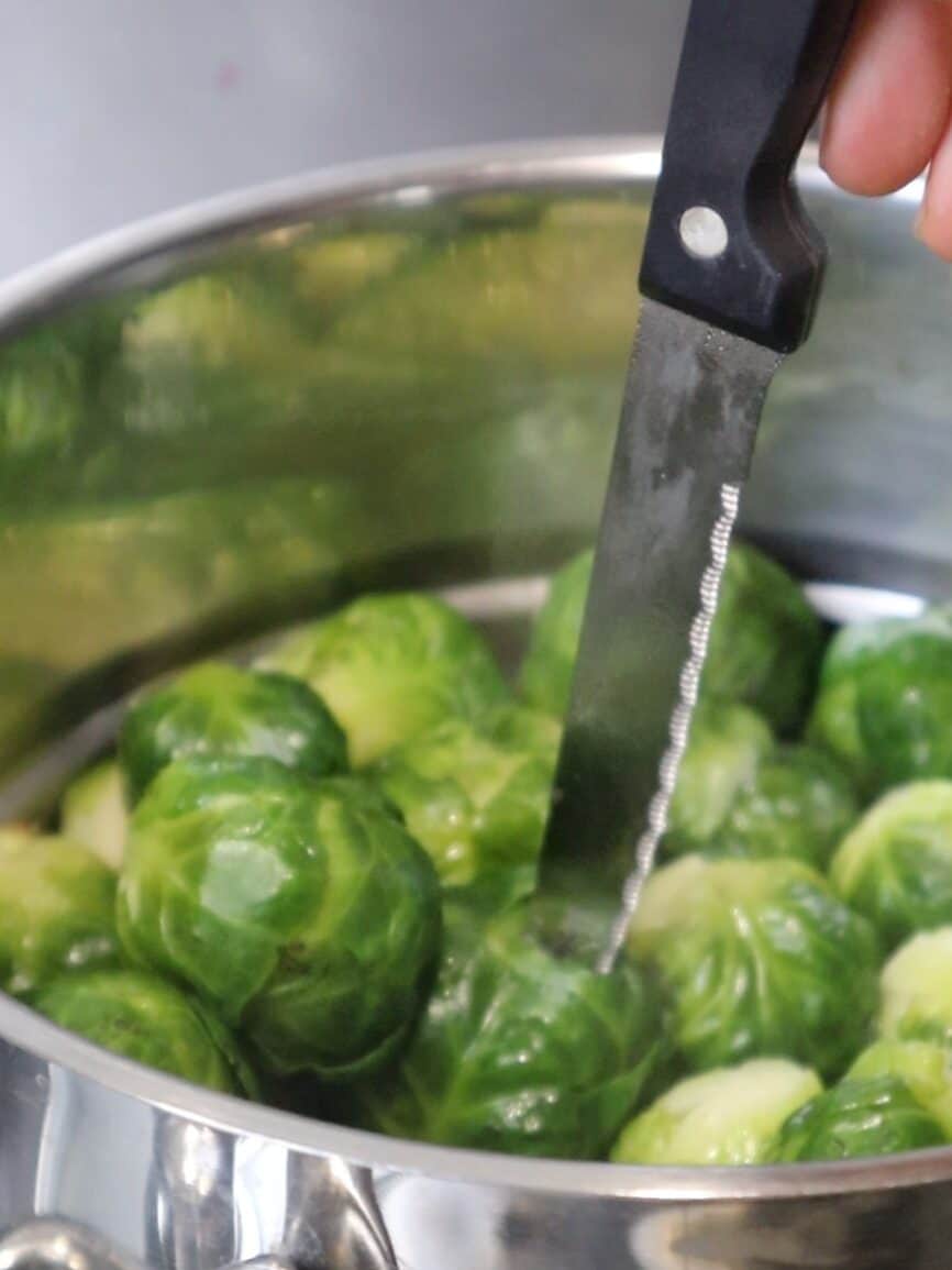 checking if brussel sprouts are soft enough with a knife