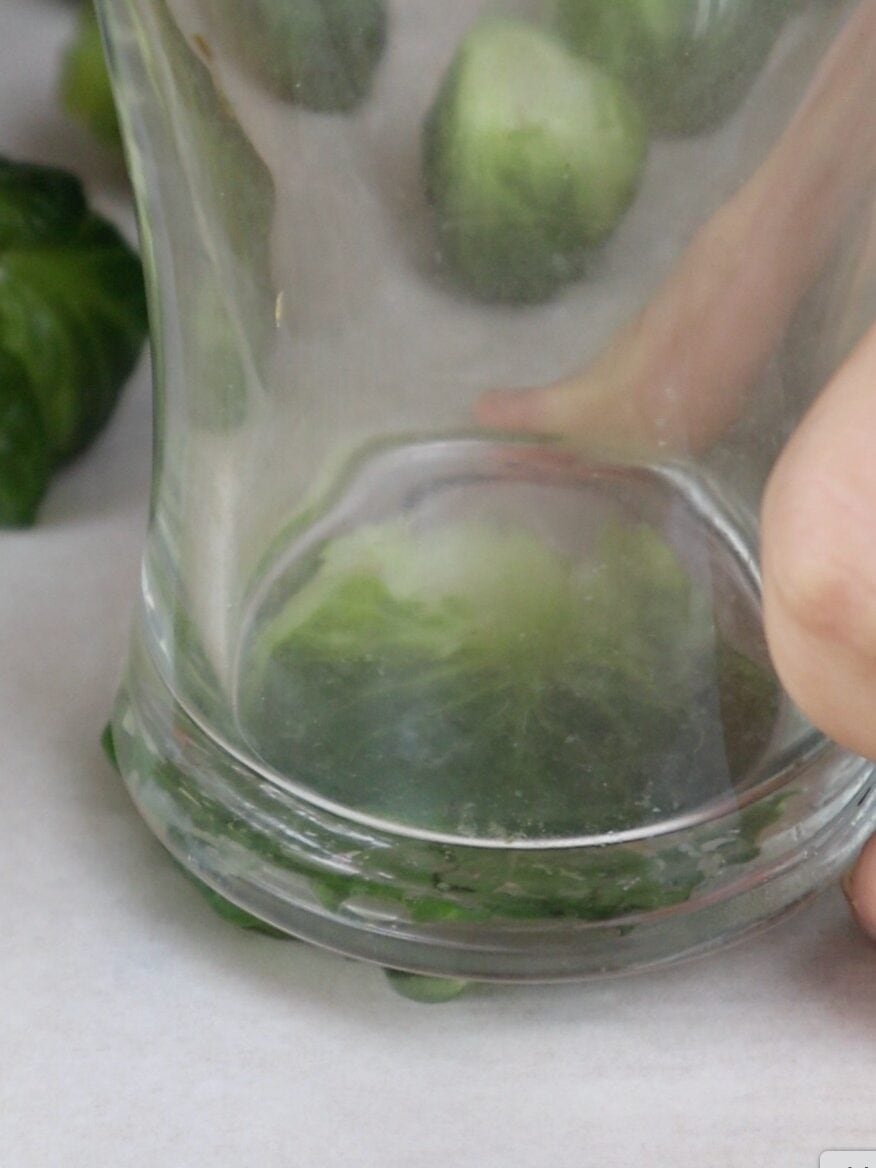 smashing brussel sprouts flat with a glass